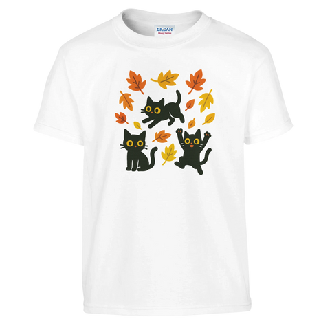 Barn t-shirt med tre svarta katter som leker bland höstlöv.