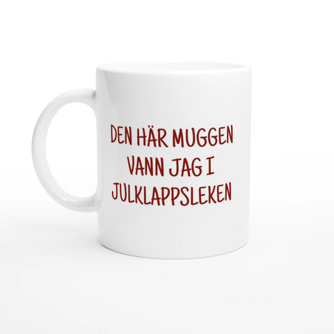 Vit mugg med röd text “Den här muggen vann jag i julklappsleken” – rolig julmugg