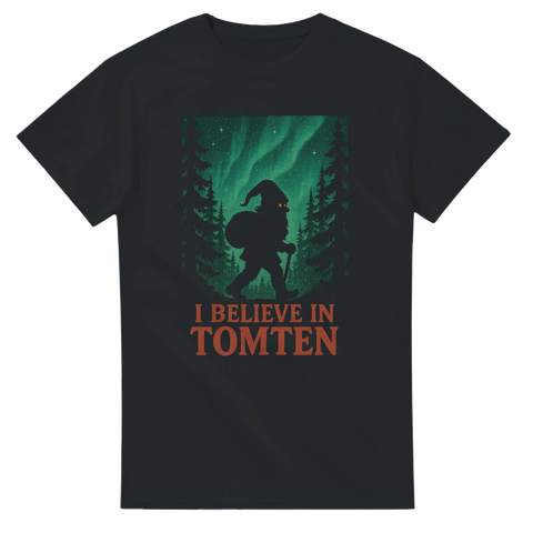 Svart t-shirt med silhuett av tomte i skogen under norrsken, texten "I Believe in Tomten"