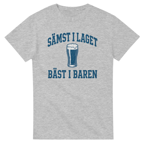 Grå t-shirt med blå tryck: texten "Sämst i laget, bäst i baren" samt en illustration av ett ölglas i mitten.
