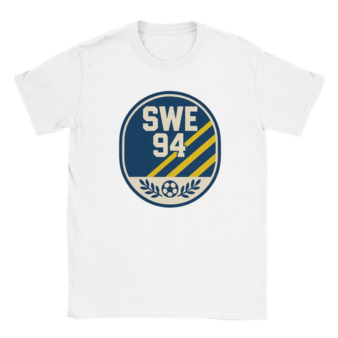 Vit t-shirt med blågul retrobadge med texten SWE 94, tre diagonala linjer och en fotbollssymbol – hyllning till Sverige 1994