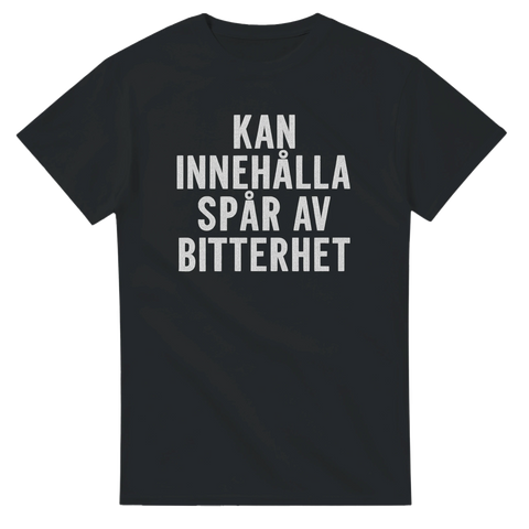 Svart t-shirt med vit text: “Kan innehålla spår av bitterhet” – en ironisk och självdistansig design för dig med syrlig humor