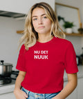 Kvinna i köksmiljö bärande en t-shirt med statement-tryck