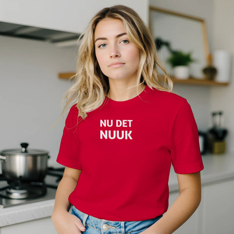 Kvinna i köksmiljö bärande en t-shirt med statement-tryck