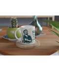 Vit kaffemugg med skämtsamt motiv placerad på ett soffbord