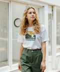 Kvinna i vit t-shirt med Hemester-tryck och motiv av svensk natur