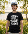Leende kille i studentmössa bär t-shirt med roligt citat utomhus