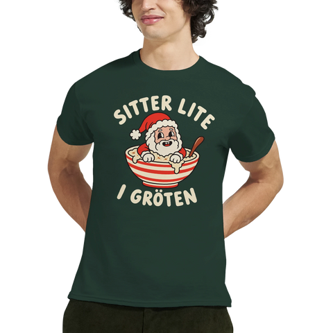 Modell i mörkgrön t-shirt med en tomte i julgröt och texten ”Sitter lite i gröten”.