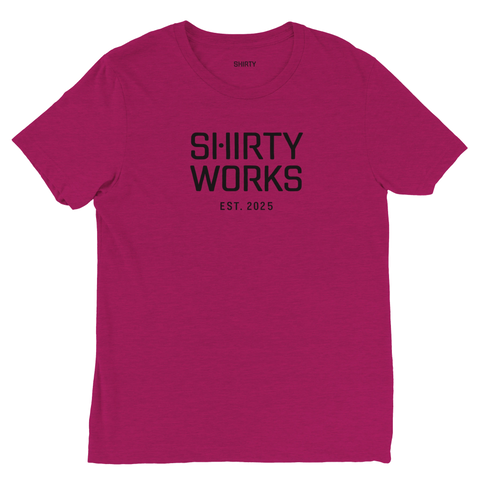 Svart "SHIRTY WORKS EST. 2025" logotyp på mörklila triblend t-shirt.