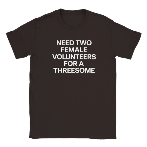 Texten "NEED TWO FEMALE VOLUNTEERS FOR A THREESOME" i vitt på en mörkbrun t-shirt.
