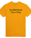 Svart text "I'm Old School I Know Things" på senapsgul t-shirt med rund hals.