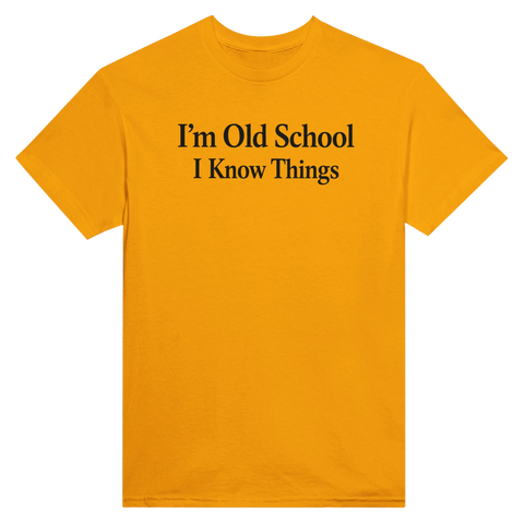 Svart text "I'm Old School I Know Things" på senapsgul t-shirt med rund hals.