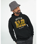 Svart hoodie med "ORTEN 112 ACAB din mamma" i guldgult och vitt, modell bär grå bucket hat.