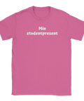 Vit text "Min studentpresent" i lekfullt typsnitt på rosa t-shirt med rund hals.