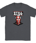 Jeffrey Epstein-porträtt i rött/vitt med text "STILL ALIVE" på mörkgrå t-shirt.