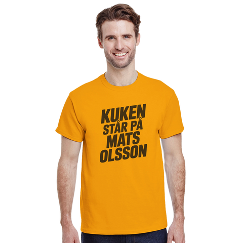 Kuken står på Mats Olsson" text på senapsgul t-shirt, satirisk design.