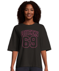 Kvinna bär en mörk oversized t-shirt med rosa Queen 69 motiv
