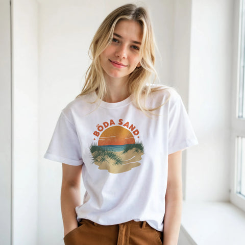 Kvinna bär vit t-shirt med nostalgiskt grafiskt Böda Sand-motiv