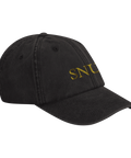 Svart baseballkeps med broderad text i guld. På kepsen står det "SNUS" i guldfärgade bokstäver.