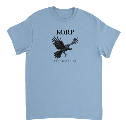 Detaljerad svart korp med utbredda vingar och text "KORP CORVUS CORAX" på ljusblå t-shirt.