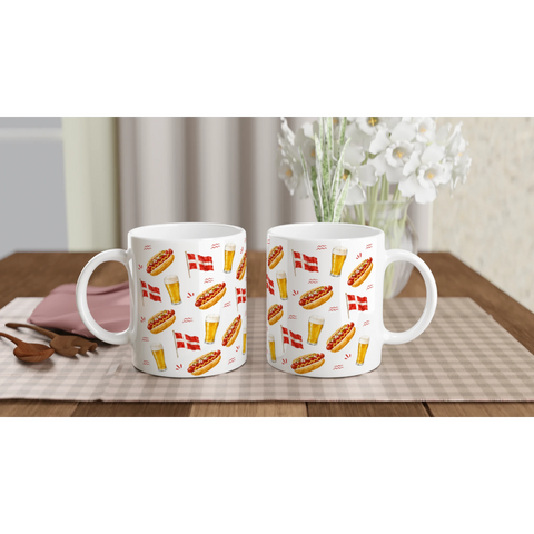 Två kaffemuggar med illustrationer av pølse och öl på ett dukat bord