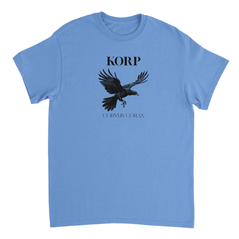 Detaljerad illustration av en flygande korp med texten "KORP" och "CORVUS CORAX" på ljusblå t-shirt.