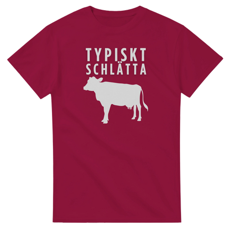 Vintage-inspirerat tryck med en ko och texten Typiskt Schlätta på en vinröd t-shirt