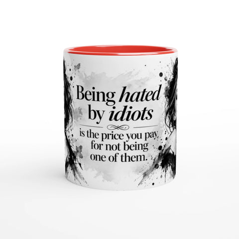 Mugg med texten Being hated by idiots och ett svartvitt kvinnoporträtt.