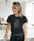 Kvinna bär en retroinspirerad t-shirt med grafiskt blommotiv och text