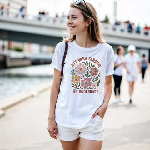 Leende kvinna utomhus i vit t-shirt med grafiskt blomtryck