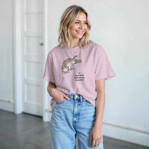 Tecknad katt som chillar med texten "Chilla är en sport och jag är en atlet" på rosa t-shirt.