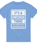 It's a Swedish Thing" text på ljusblå t-shirt med distressed vit rektangulär ram.