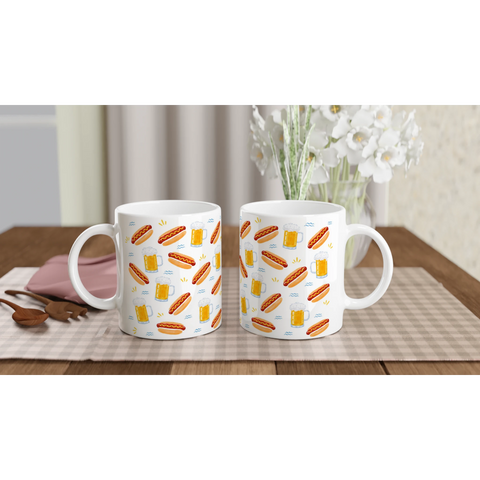 Två kaffemuggar med mönster av korv och öl i en köksmiljö