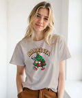 Modell i beige t-shirt med en kaffeserverande julgran och texten ”Barrista”.