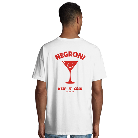 Negroni-cocktailglas med leende ansikte och text "Keep it cold please" på vit oversized t-shirt.