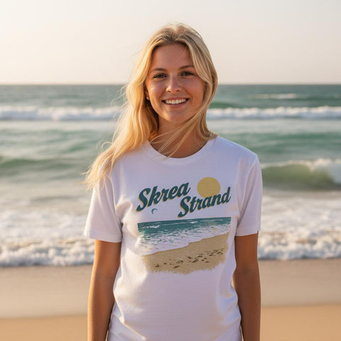 Kvinna bär t-shirt med somrigt kustmotiv vid havet i solnedgång