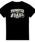 Svart t-shirt med texten Promoted to Dad 2027, nappflaska och napp.