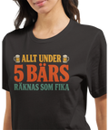 Modell i en mörkgrå t-shirt med texten Allt under 5 bärs räknas som fika i retrofärger.