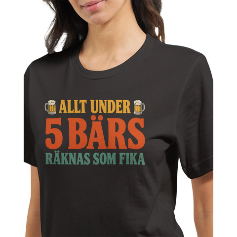 Modell i en mörkgrå t-shirt med texten Allt under 5 bärs räknas som fika i retrofärger.