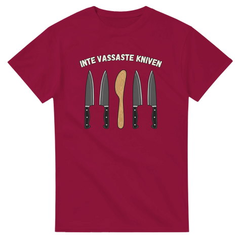 Humoristisk illustration av en smörkniv bland kockknivar på vinröd t-shirt