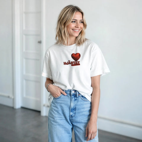 Rött 3D-hjärta med text "HJÄRTAT TILL VÄNSTER" på vit t-shirt, minimalistisk design.