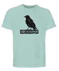 Svart korp på skylt "Adapt or Disappear" på mintgrön T-shirt.
