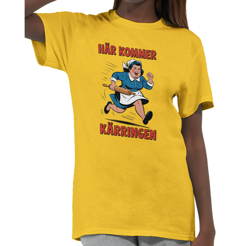 Seriefigur av arg kvinna med kavel, text "HÄR KOMMER KÄRRINGEN", på gul t-shirt.