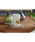 Vit mugg med retroinspirerat bakverksmotiv placerad på ett soffbord