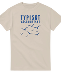 Blå text "TYPISKT VÄSTKUSTSKT" med flygande måsar på beige t-shirt.