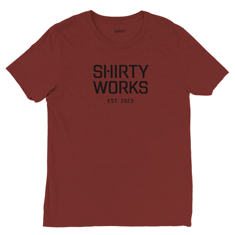 Shirty Works EST. 2025" texttryck i svart på rödbrun triblend t-shirt.