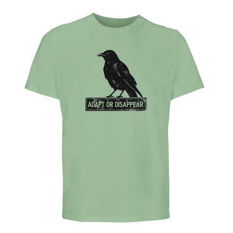 Svart kråka med texten "ADAPT OR DISAPPEAR" på en mintgrön ekologisk t-shirt.