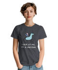Tecknad ljusblå enhörning med rosa/blå vingar och text på mörkgrå t-shirt.