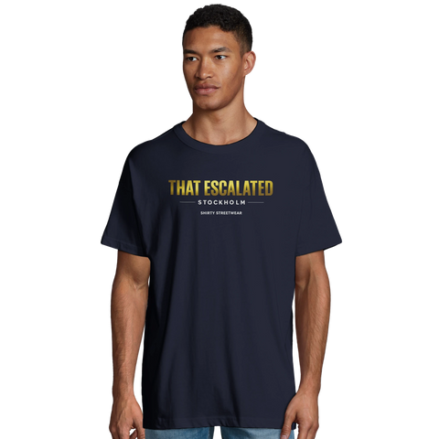 Man bär mörkblå t-shirt med kaxig guldtext och urban attityd