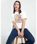 Kvinna i jeans bär vit t-shirt med vintage blommotiv